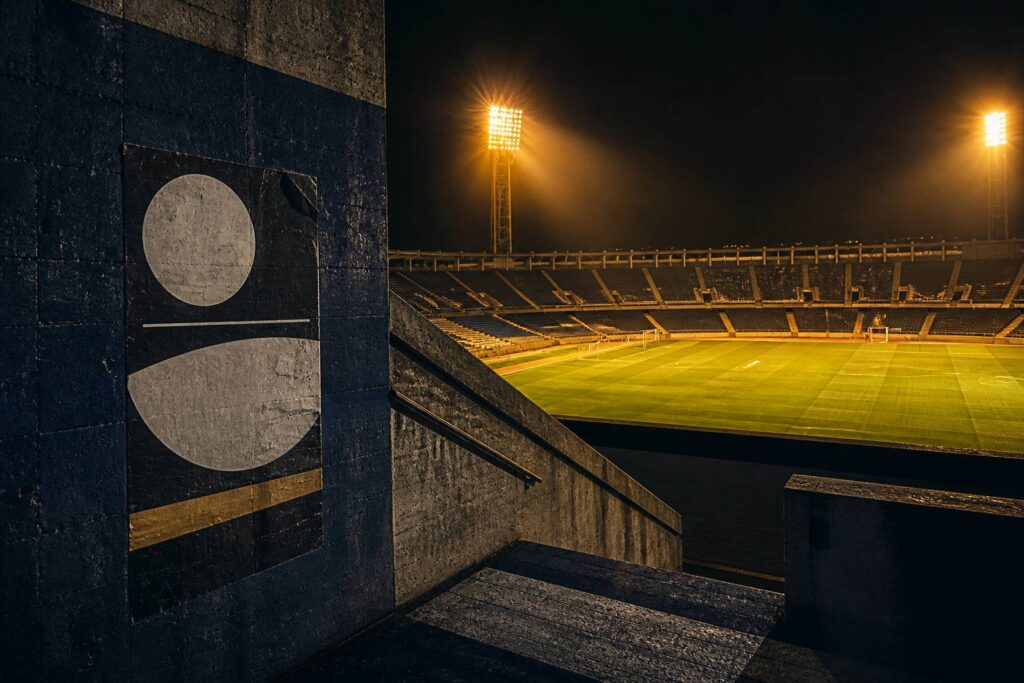 Stade de football sous les projecteurs jaunes en soirée de match